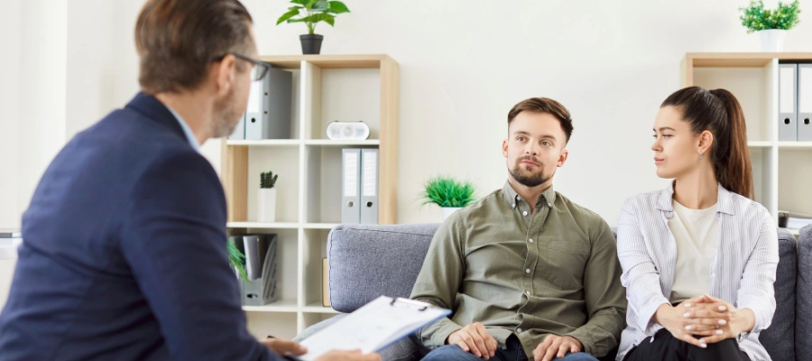Image of a male and female sitting next to each other talking with a counselor holding a notepad -Alcohol Rehab Idaho Programs at Icarus Wellness