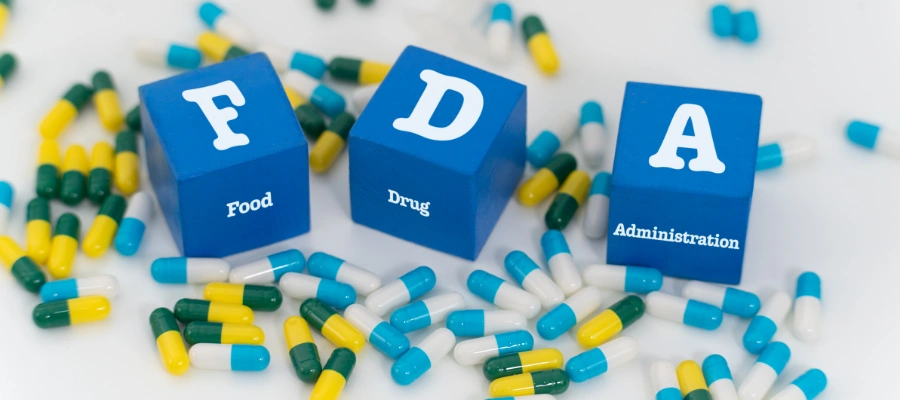 Image of pills on a table surround by F, D and A cubes - FDA Approved Medications Available for Alcohol MAT