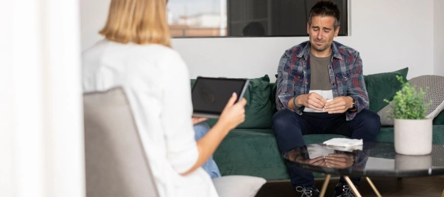 Image of a man sitting in therapy with a counselor listening - Residential inpatient treatment program