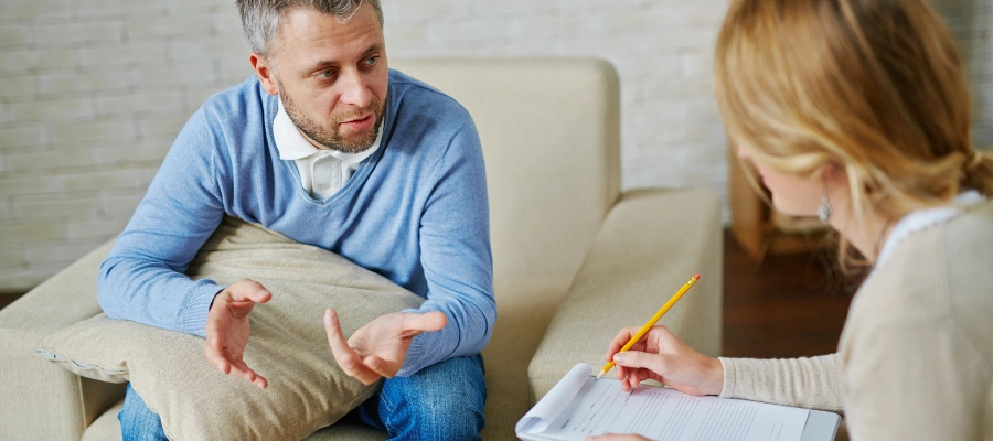 Image of a doctor interviewing a male patient to treat his co-occurring disorders in addiction recovery