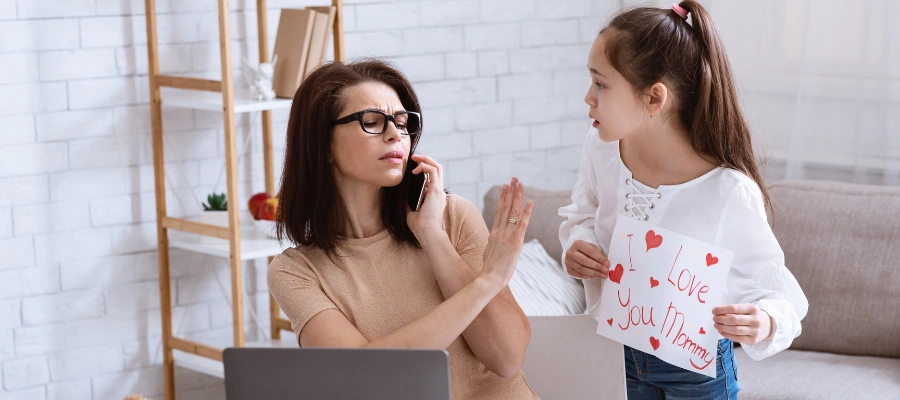 Image of a woman sitting and talking on the phone, brushing off her daughter holding the sign "I Love You Mommy - Neglect as a Child - Examples of Adverse Childhood Experiences