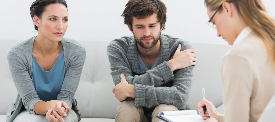 Image of  a man in woman in group therapy talking to a counselor 