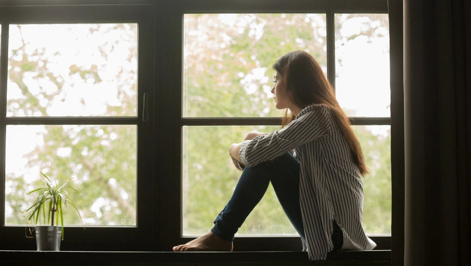 Image of a woman sitting in front of a window - How to Treat Childhood Trauma in Adults - Icarus Wellness