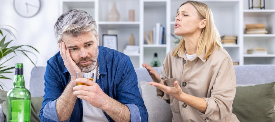 Image of couple arguing at home, showing relationship strain caused by alcohol abuse