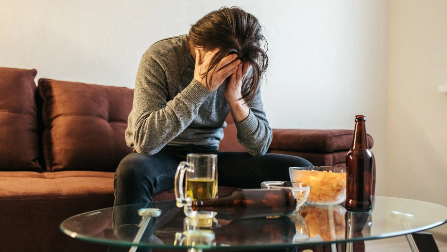 Image of a man sitting in pain with his hands on his face - What is the Alcohol Withdrawal Kindling Effect - Icarus Wellness