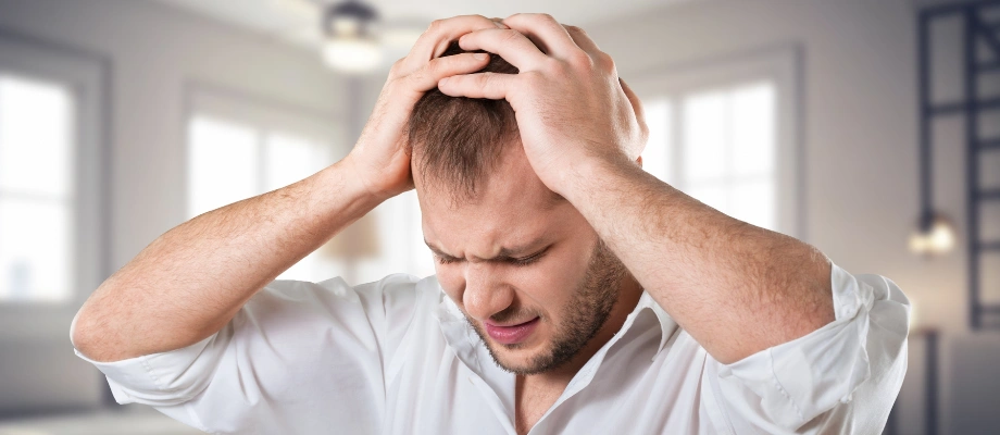 Image of a man sitting alone, looking down, and showing his depression and emotional struggle during alcohol withdrawal