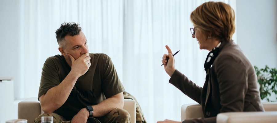 Image of a therapist talking with a military veteran about mental health and addiction, symbolizing dual diagnosis treatment and holistic recovery