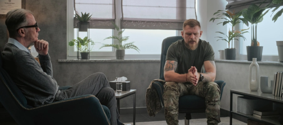 Image of a veteran meeting with a therapist in a calm rehab setting, representing residential and outpatient dual diagnosis treatment options