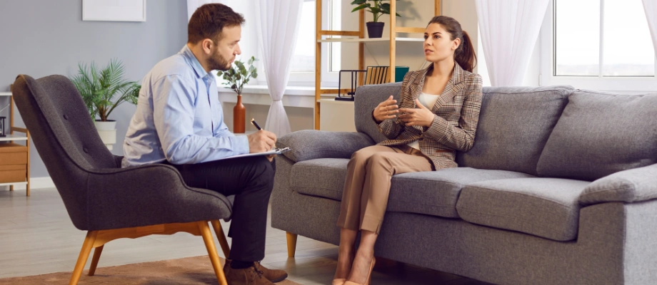 Image of a woman sitting in counseling with a therapist, discussing her seasonal affective disorder and alcohol recovery