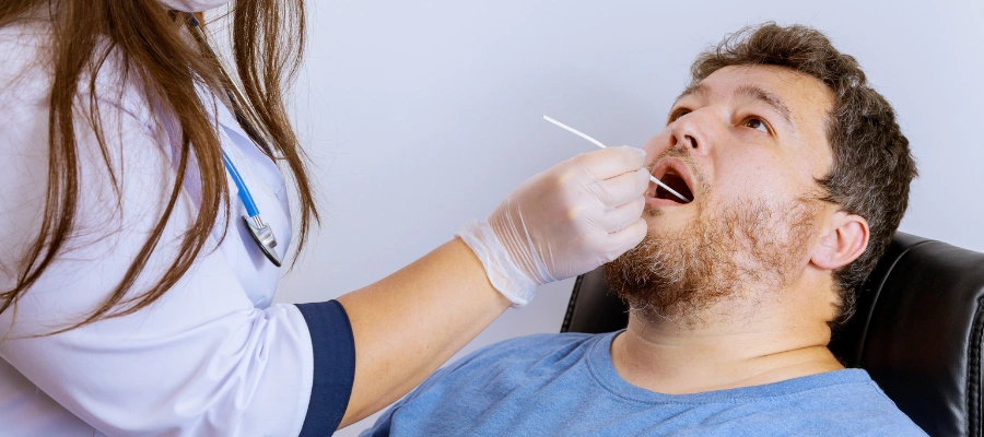 Image of a healthcare professional collecting a saliva sample from a patient for alcohol testing