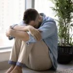 Image of a man in despair, sitting on the floor with his face next to his knees - Can You Check Yourself Out of Rehab - Icarus Wellness and Recovery