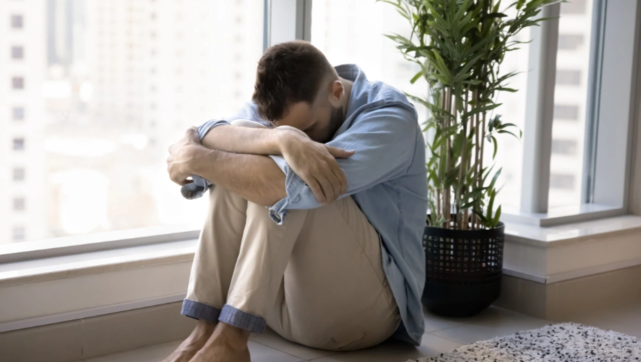 Image of a man in despair, sitting on the floor with his face next to his knees - Can You Check Yourself Out of Rehab - Icarus Wellness and Recovery
