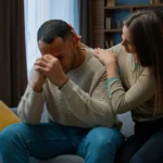 Image of a woman sitting on a sofa consoling a man - How to Support Someone With CPTSD - Icarus Wellness and Recovery