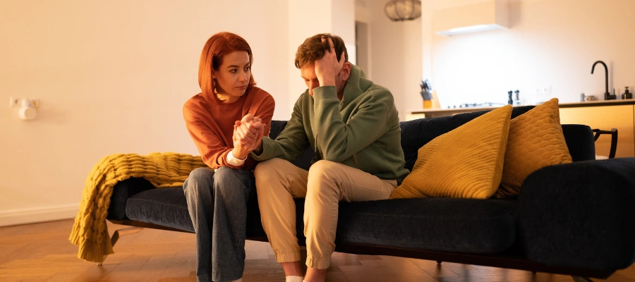 Image of a woman offering attentive, non-judgmental support to a man siting next to her