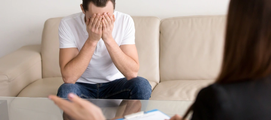 Image of trauma-informed therapist conducting a supportive counseling session with a client to address his CPTSD symptoms