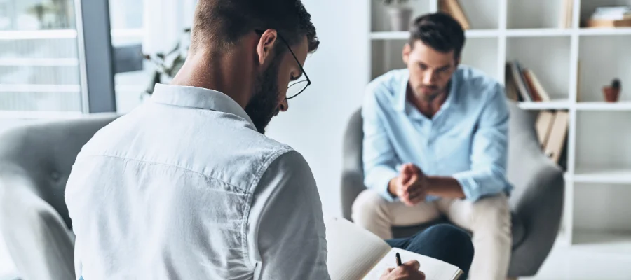 Image of a man in therapy session preparing relapse prevention plan with therapist
